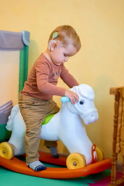 Photo of Shot of a deaf baby playing