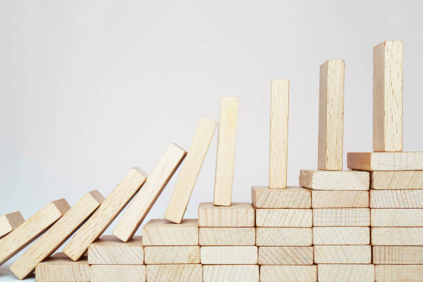 istock Domino effect climbing the stairs on a wooden staircase lined with steps. 1454450177
