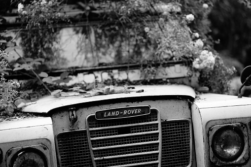 Manchester, United Kingdom – December 22, 2022: Manchester UK Dec 2022 old damaged Land rover 4 x 4 off road vehicle rotting away showing badge grill and bonnet