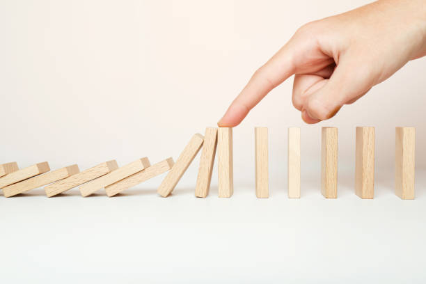 istock Hand stopping the Domino effect stopped by unique, 1454451071