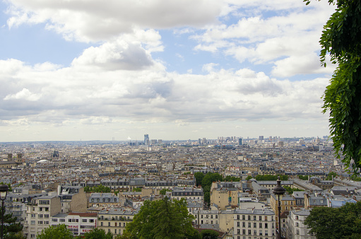 Views of city buildings Paris  from a height, with tourists walking along the streets