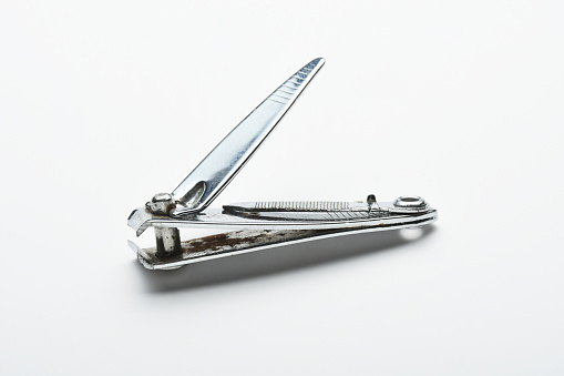 Stainless steel old and rusty nail clipper on the white background