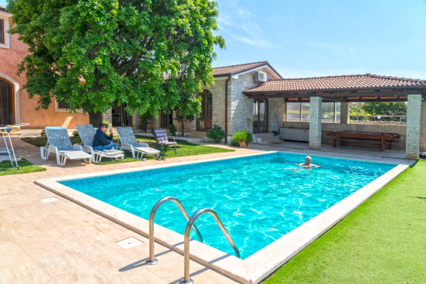 istock Two people enjoying in swimming pool at vacation villa 1454455286