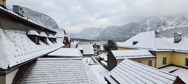 A winter view of buildings with mountains in background in Hallstatt, Austria