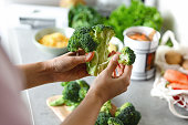 Woman's hand peeling broccoli