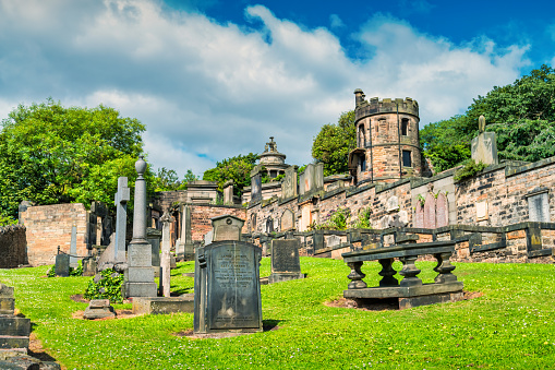 Calton Cemetery in Old Town Edinburgh Scotland with the Watchtower and the Burns Monument in the background.