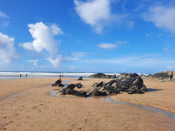 istock Beautiful shot of rocks on a beach under a cloudy blue sky 1454463579