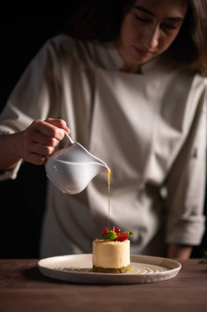 istock A female chef pouring sauce on a fruitcake 1454475262