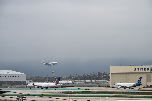 Commercial airplane preparing for landing with runway approach lights in the foreground.