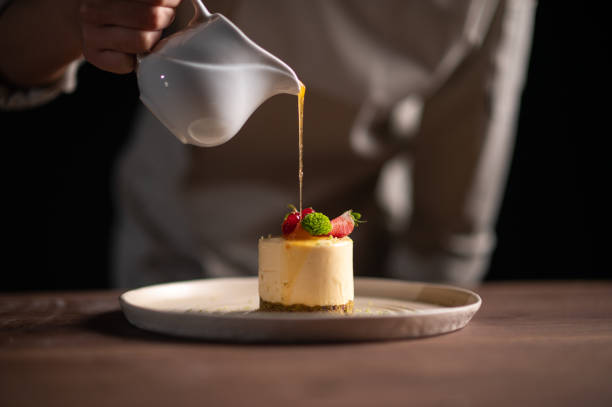 женщина-шеф-повар наливает соус на фруктовый торт - dessert tiramisu gourmet food стоковые фото и изображения