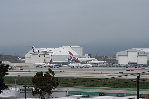 Logan International Airport, Boston Massachusetts, USA - October 2023.  Aircraft on the hard standing and the runway at the airport.