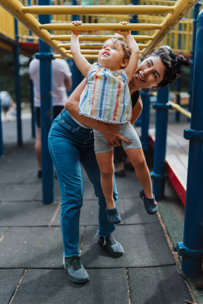 istock Toddler girl learning to use the monkey bars at the park 1454481089