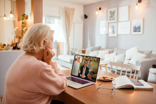 Close up of a senior woman talking to her counsellor over a video call