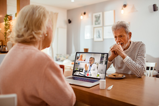 Close up of a senior couple talking to their doctor over a video call