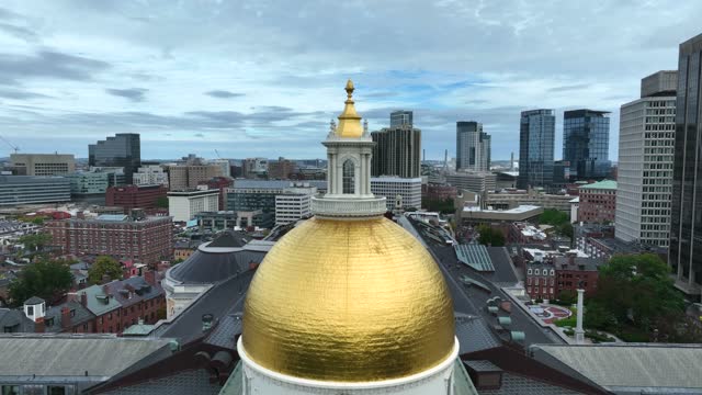 Rising aerial of Boston Statehouse located in the Beacon Hill neighborhood of Boston, MA. Known as the Massachusetts State House or New State House, the building is in urban state capital, Boston.