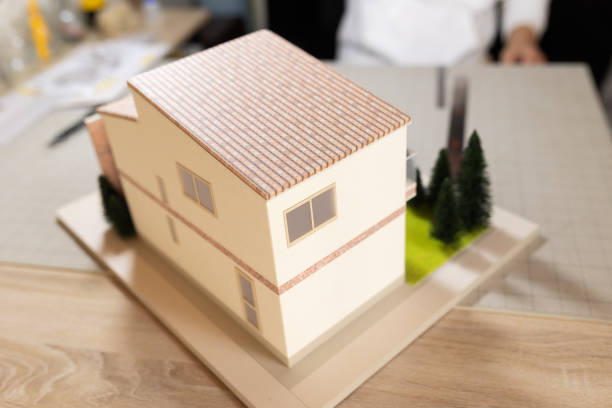 A close up view of a two-story model house on a desk used by architects to show clients the design of a house.