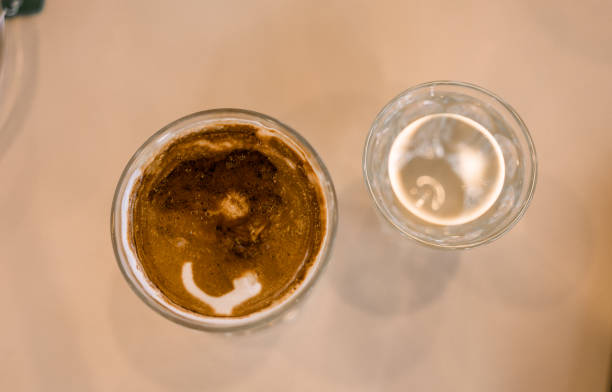 Dirty coffee iced latte freeze milk pour espresso shot in a cup of coffee on scale measurement served with cool water.