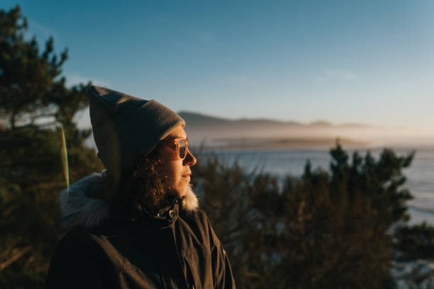 istock Woman enjoying winter sunset at the beach 1454497573