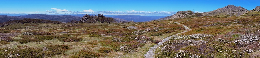 Panorama of snowy mountains landscape in Australia showing walking trail and spectacular mountains