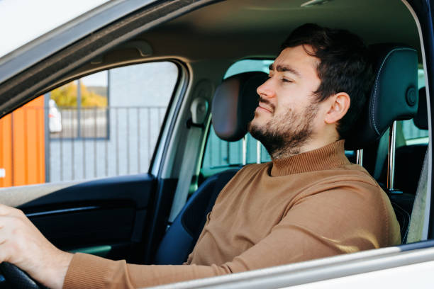 istock Man in his car behind wheel, dressed in a brown sweater 1454497827