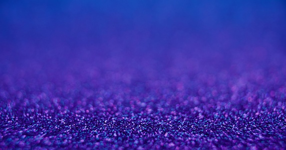 Bokeh light background. Product placement. Bubbles texture. Defocused neon purple blue color gradient sparkles abstract copy space wallpaper.