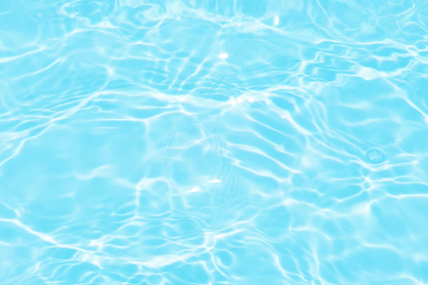 istock Defocus blurred transparent blue colored clear calm water surface texture with splashes and bubbles. Trendy abstract nature background. Water waves in sunlight with caustics. Blue water spay shinning 1454503804