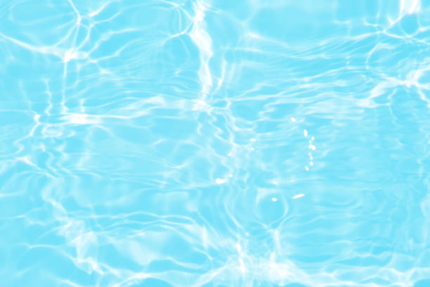 istock Defocus blurred transparent blue colored clear calm water surface texture with splashes and bubbles. Trendy abstract nature background. Water waves in sunlight with caustics. Blue water spay shinning 1454503814