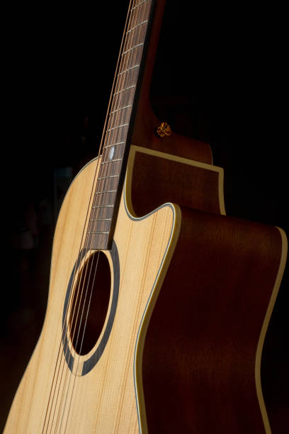 istock Classic Acoustic GA guitar with Satin Finished close up, dramatically lit on a black background with copy space 1454509674