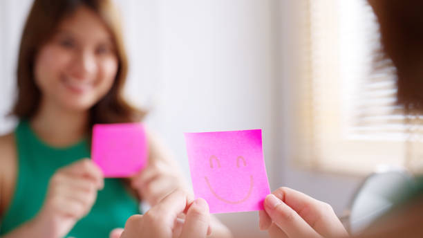 Smiling faces drawn on pink sticky note. Isolated on white background with Clipping path. Start the Day with a Positive Mind.
