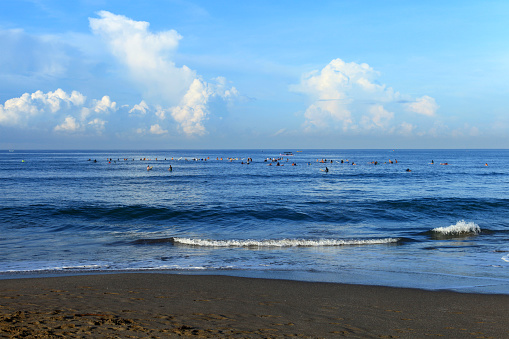 Surfers riding longboard waves at Batu Bolong Beach in Canggu, Bali, Indonesia. Batu Bolong is famous for riding long boards in Bali.