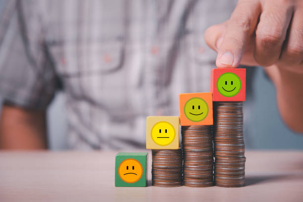 istock man hand point on tallest coin stack with smile icon wood cube 1454520757
