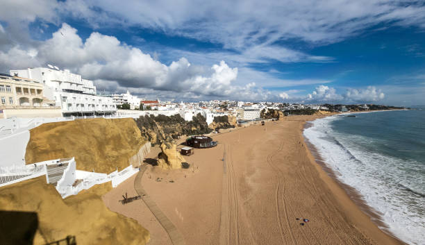 Beachfront of Albufeira, Portugal with clouds in blue sky stock photo
