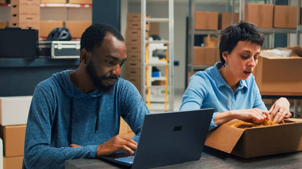 istock Diverse partners checking quality of goods before packing them in cardboard boxes 1454525076