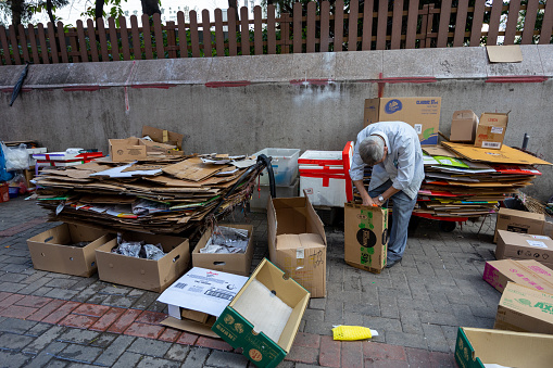 Hong Kong - December 31, 2022 : Cardboard collector picks up discarded packing boxes in Tuen Mun, New Territories, Hong Kong.