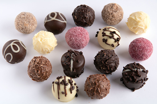 Photo of different chocolate round sweets close-up on a white background