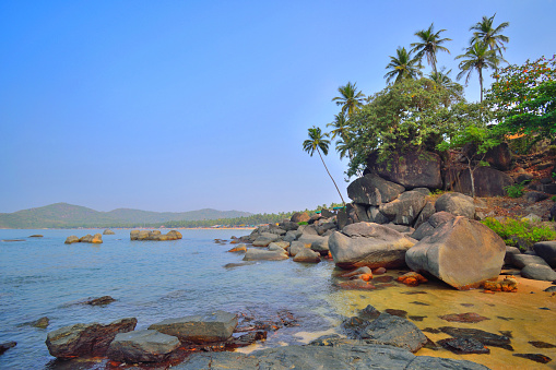 Large rocks scattered at Palolem beach in Goa.