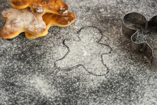Christmas cookie man on the table with flour and metal shape