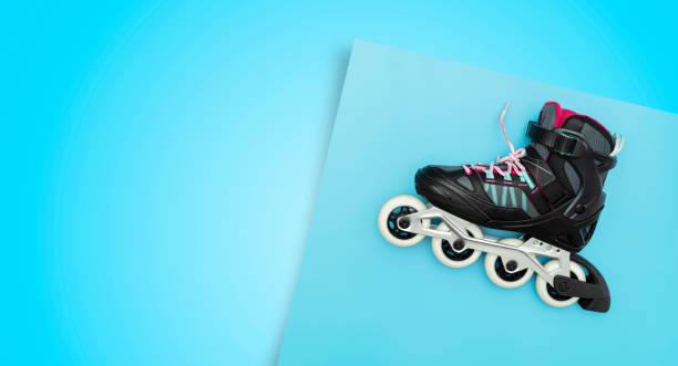 istock Black single row roller skates on a blue background. Stylish roller skates on blue background, top view. 1454530702