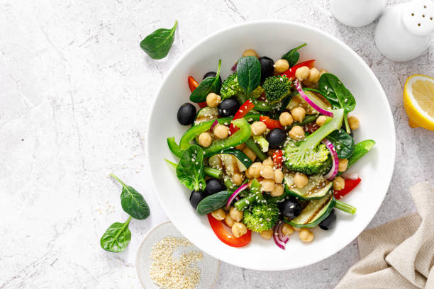 Chickpea and spinach vegan vegetable salad with broccoli, sweet pepper, olives and grilled zucchini. Mediterranean diet, healthy food. Top view Chickpea and spinach vegan vegetable salad with broccoli, sweet pepper, olives and grilled zucchini. Mediterranean diet, healthy food. Top view sesame photos stock pictures, royalty-free photos & images