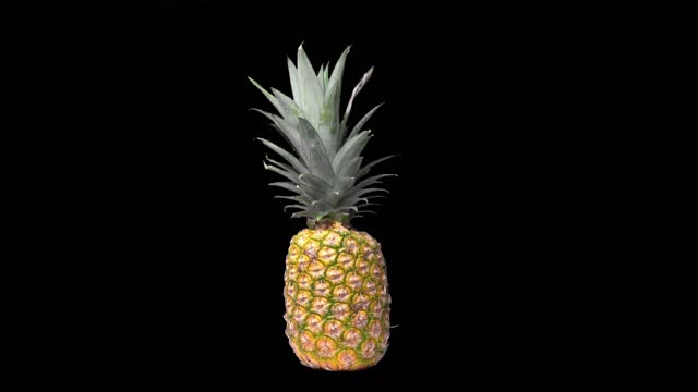 Animation of a pineapple spinning clockwise on black background