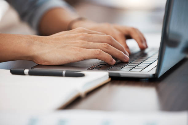 istock Typing, hands and man doing work on laptop in office with notebook on desk. Technology, internet and businessman with computer writing emails, working on project and type documents on keyboard 1454536073