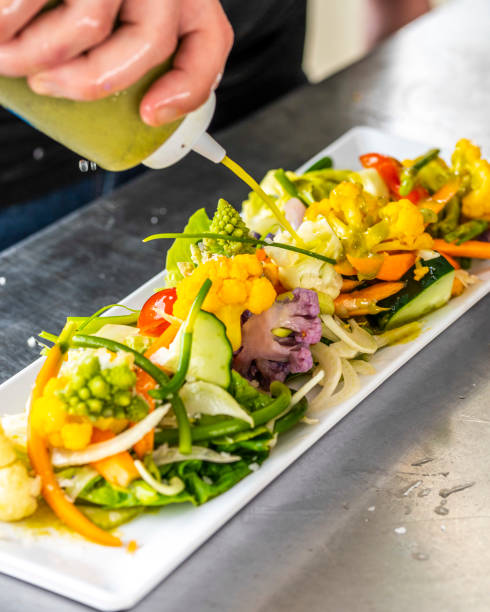 Dressing a Salad - the final step before chefs salad leaves the kitche