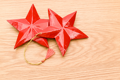 red painted decorative wooden star on a wooden background with copy space
