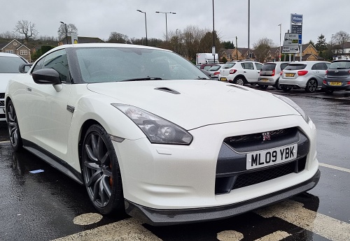 Bristol, United Kingdom – January 03, 2023: A front view of a white Nissan GTR Nismo in a parking lot on a rainy day