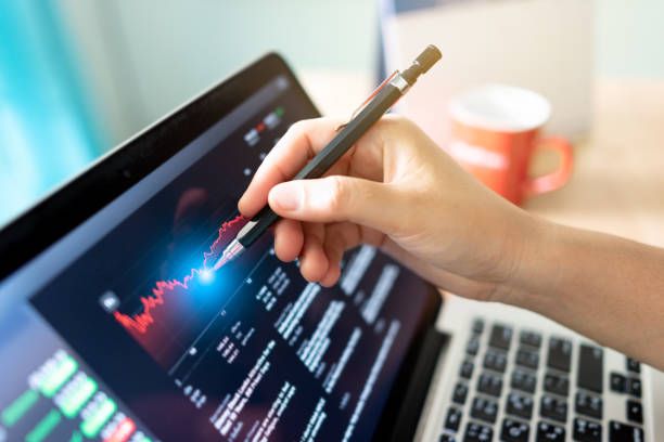 istock business people looking at fluctuating stock graphs 1454540439