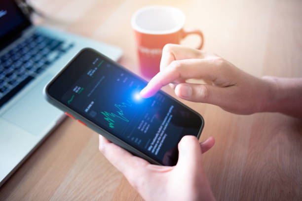 istock Businessman looking at fluctuating stock chart on mobile phone 1454540447