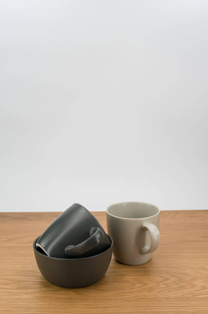 灰色の空の石器のボウルとマグカップを木製の卓上に積み上げた - earthenware bowl ceramic dishware ストックフォトと画像