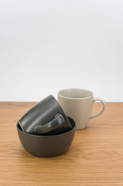 灰色の空の石器のボウルとマグカップを木製の卓上に積み上げた - earthenware bowl ceramic dishware ストックフォトと画像
