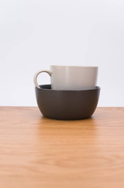 灰色の空の石器マグカップをコピー用スペース付きの木製の卓上に積み上げた - earthenware bowl ceramic dishware ストックフォトと画像