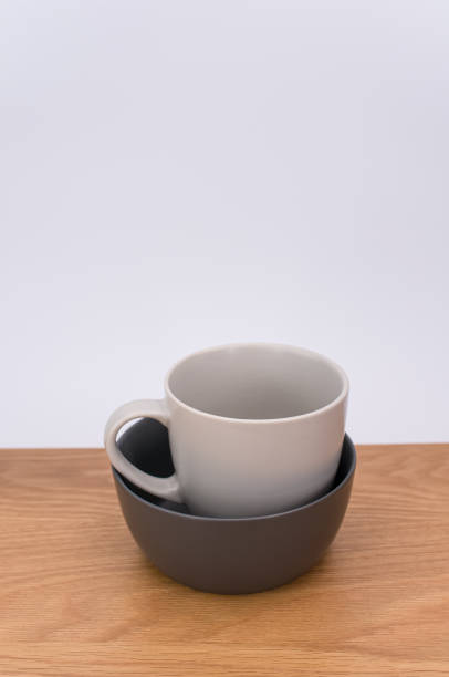 灰色の空の石器マグカップをコ�ピー用スペース付きの木製の卓上に積み上げた - earthenware bowl ceramic dishware ストックフォトと画像